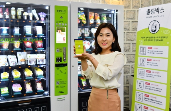 풀무원 직원이 스마트 자판기 ‘출출박스’전용 모바일 앱(App)을 선보이고 있다. 사진=풀무원.